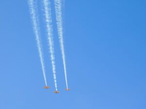 PHoto of three bi-laines streaking across a bright blue sky.